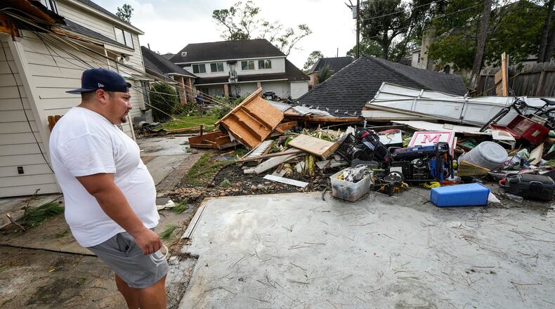 Guillermo Vargas surveys damage to his home, where his garage was swept off its foundation, while cleaning up storm damage after severe weather hit in the Memorial Northwest subdivision, in Spring, Texas, Monday, Nov. 24, 2025. (Brett Coomer/Houston Chronicle via AP)