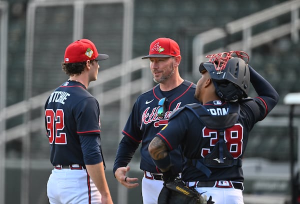Braves pitching coach Jeremy Hefner (center) chats with pitcher JR Ritchie (left) and catcher Chadwick Tromp.