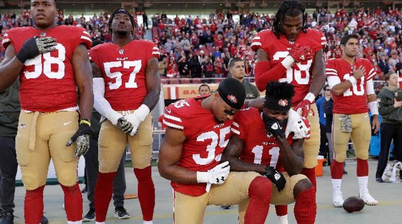 San Francisco 49ers safety Eric Reid (35) and wide receiver Marquise Goodwin (11) kneel during the performance of the national anthem before an NFL football game against the New York Giants in Santa Clara, Calif., Sunday, Nov. 12, 2017. (AP Photo/Marcio Jose Sanchez)