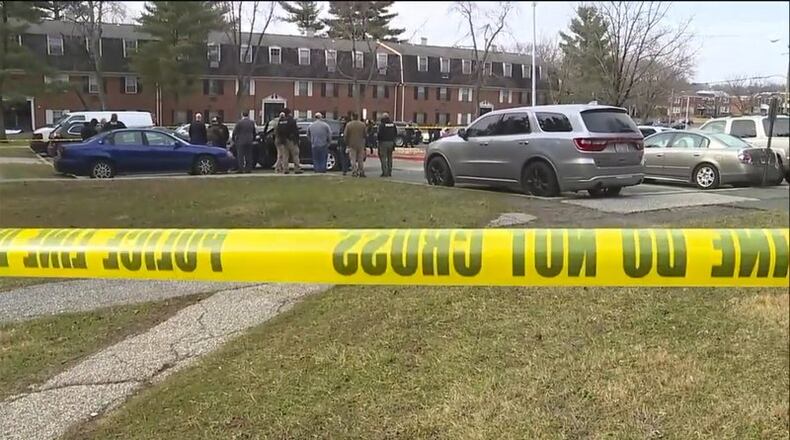 This image provided by WMAR-2 News shows emergency and law enforcement officials responding to the scene of a shooting, Wednesday, Feb. 12, 2020 in Baltimore. Two law enforcement officers with a fugitive task force were injured and a suspect died in a shooting on Wednesday, the U.S. Marshals Service said. (WMAR-2 News via AP)