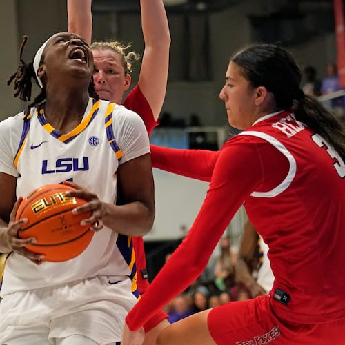 LSU forward Amiya Joyner, left front, drives the lane against Marist guard Justine Henry, right, and forward Karly Fischer , left back, during the second quarter of an NCAA college basketball game at the Paradise Jam tournament Friday, Nov. 28, 2025, in St. Thomas, U.S. Virgin Islands. (Bill Kiser/The Virgin Islands Daily News via AP)