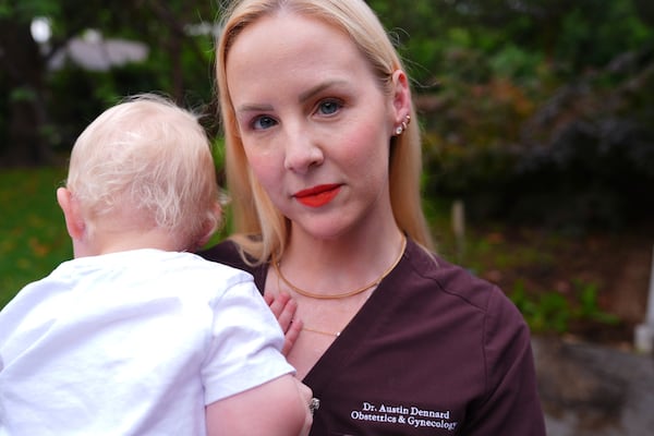 Dr. Austin Dennard holds her son as she poses for a portrait at her home in Dallas, Friday, May 2, 2025. (AP Photo/LM Otero)