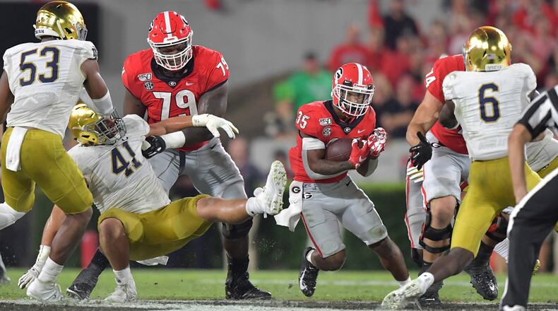 Georgia running back Brian Herrien (35) runs with the ball against Notre Dame, with Isaiah Wilson (79) blocking at Sanford Stadium in Athens on Saturday, Sept. 21, 2019. (Hyosub Shin / Hyosub.Shin@ajc.com)  **Isaiah Wilson (79 on left)**