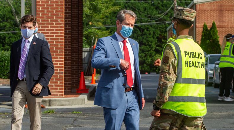 Gov. Brian Kemp talks with a member of the Georgia National Guard after touring a COVID-19 testing site in Gwinnett County. The General Assembly voted in March to give Kemp emergency powers to help the state function during the COVID-19 pandemic. Legislation now under consideration in the Georgia House would give the Legislature more control over those powers in the future. STEVE SCHAEFER FOR THE ATLANTA JOURNAL-CONSTITUTION