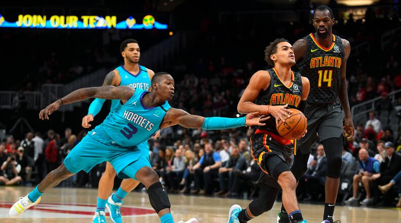 Hawks guard Trae Young drives the lane as Hornets guard Terry Rozier (3) defends during the first half of Monday's game in Atlanta. (AP Photo/John Amis)