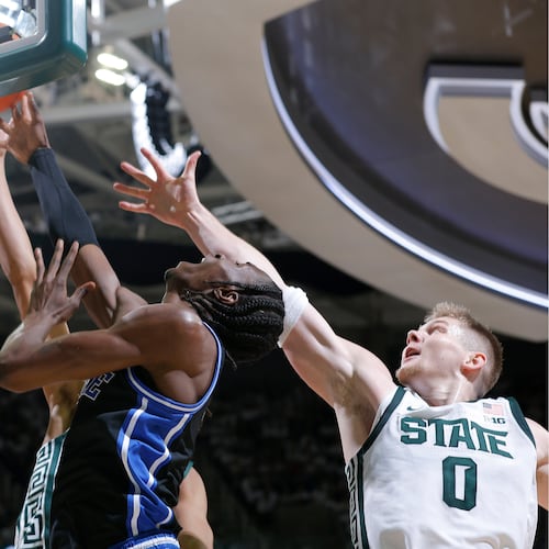 Duke guard Dame Sarr, center, and Michigan State forward Jaxon Kohler (0), right, and forward Jordan Scott, rear, vie for a rebound during the first half of an NCAA college basketball game, Saturday, Dec. 6, 2025, in East Lansing, Mich. (AP Photo/Al Goldis)