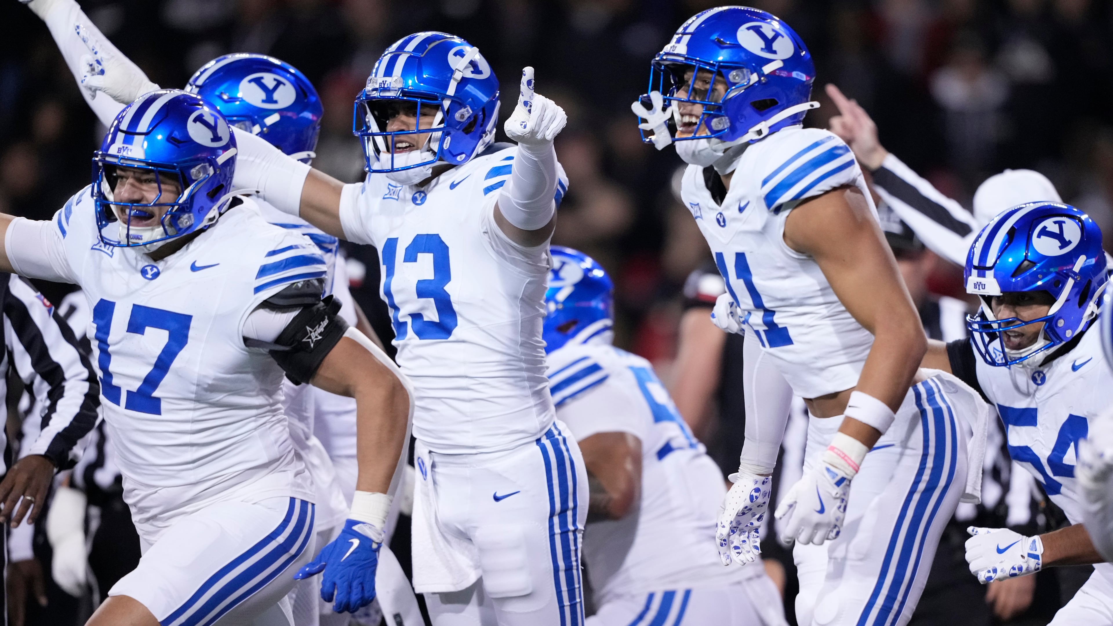 From left, BYU linebacker Jack Kelly (17), defensive lineman Tausili Akana (13), safety Faletau Satuala (11) and linebacker Siale Esera (54) celebrate as they run off the field after a turn over on downs during the first half of an NCAA college football game against Cincinnati, Saturday, Nov. 22, 2025, in Cincinnati. (AP Photo/Carolyn Kaster)