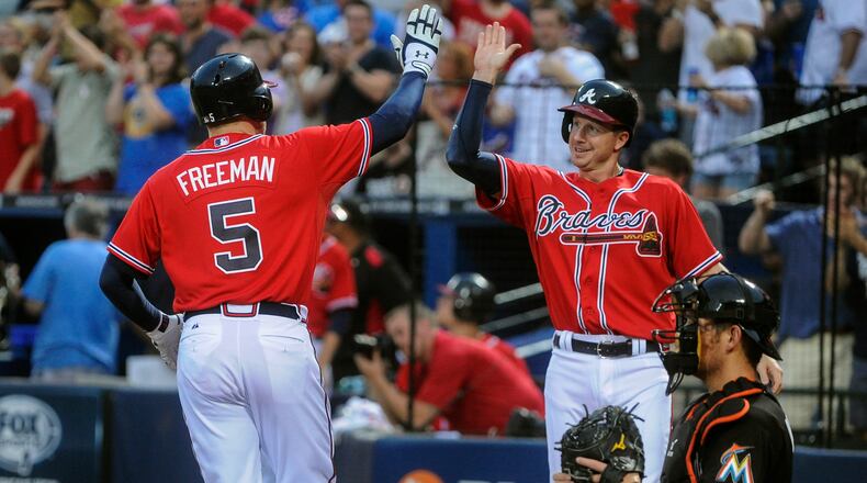 Atlanta Braves' Freddie Freeman (5) is welcomed to home plate by Elliot Johnson on Freeman's home run against the Miami Marlins during the first inning of a baseball game, Friday, Aug. 30, 2013, in Atlanta. Atlanta won 2-1. (AP Photo/John Amis)