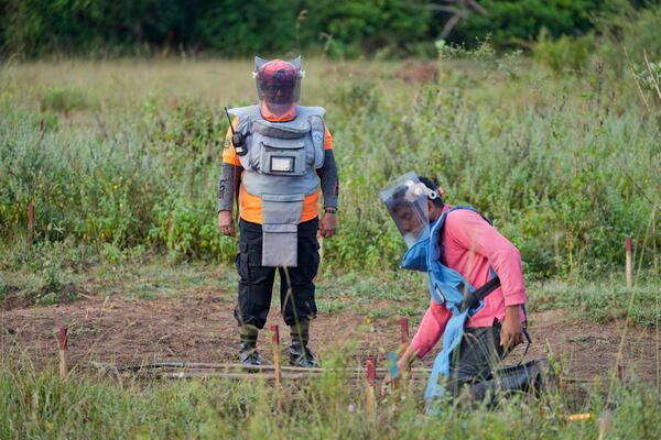 Thavarathnam Pushparani, left, monitors a fellow worker as they work in a contaminated mining area in Mankulam, Sri Lanka, Thursday, April 3, 2025. (AP Photo/Eranga Jayawardena)