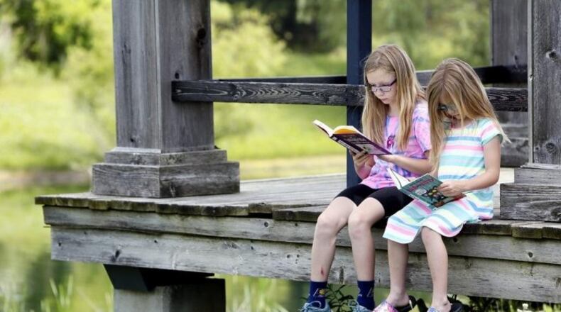 An important element to getting kids to love reading is  parents reading to them and with them at home. Here two sisters read books they recently checked out of the library with their grandmother.