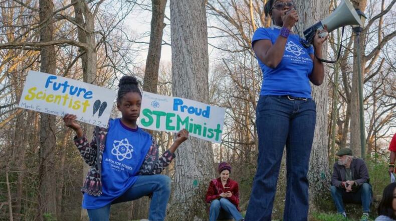 Dr. Jasmine Clark, a microbiologist who organized the Atlanta March for Science, promoted the Earth Day march at a women’s rally on March 8 at Candler Park. Her 8-year-old daughter, Jayda, held signs nearby.