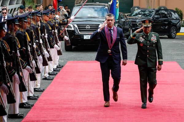 U.S. Defense Secretary Pete Hegseth, center, along with Armed Forces of the Philippines Chief of Staff General Romeo Brawner, salutes troops upon arriving at the Armed Forces of the Philippines Headquarters in Camp Aguinaldo in Quezon City, Philippines, Friday, March 28, 2025. (AP Photo/Gerard Carreon)