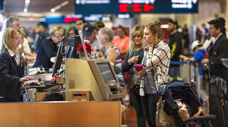 Passengers line up at the Delta counter at Palm Beach International Airport Monday morning, Dec. 18, 2017. South Florida airports had some delays on flights to Atlanta after Sunday night’s power outage at Hartsfield-Jackson International Airport. (Lannis Waters / The Palm Beach Post)