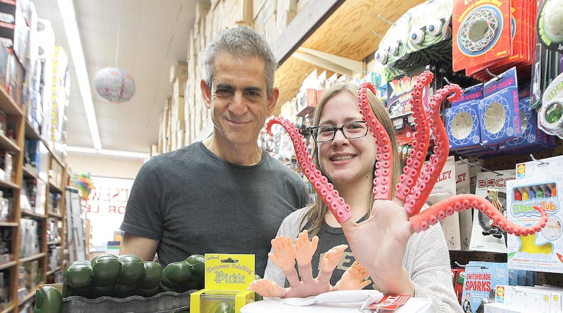 Owner Robert Klenberg and manager Rachel Wagner display items for sale at Richard’s Variety in Peachtree Battle shopping center, including the Human Organ for Transplant lunch carrier, Bobo Christmas ornament, Electronic Yodeling Pickle and tentacle fingers .Thursday, November 10, 2016. CONTRIBUTED BY TAMI CHAPPELL