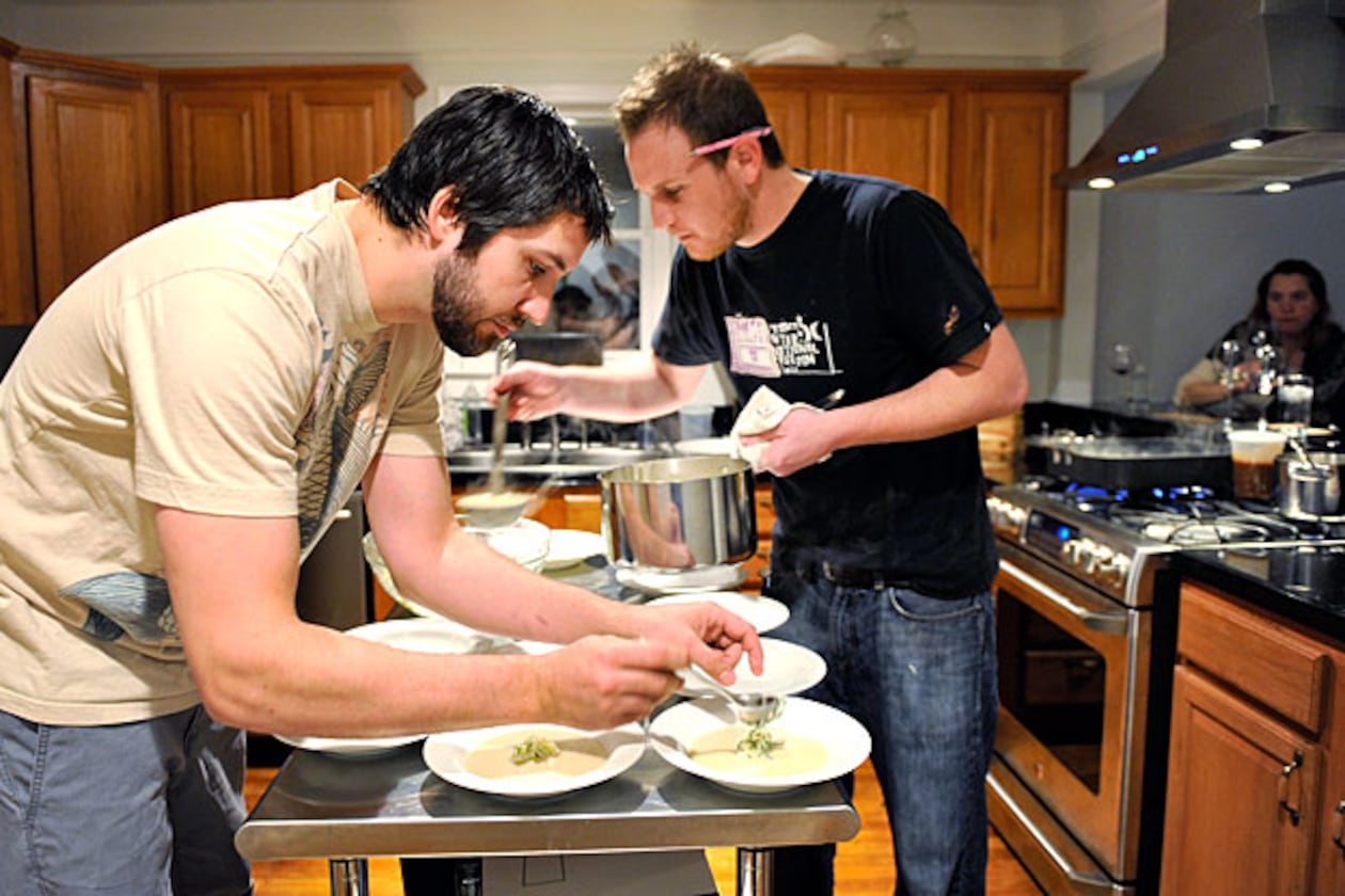 Ryan Hidinger (left) and his sous-chef Ben Barth serve fennel soup with apple relish at the Jan. 31 seating of Prelude to Staplehouse, an underground supper club.