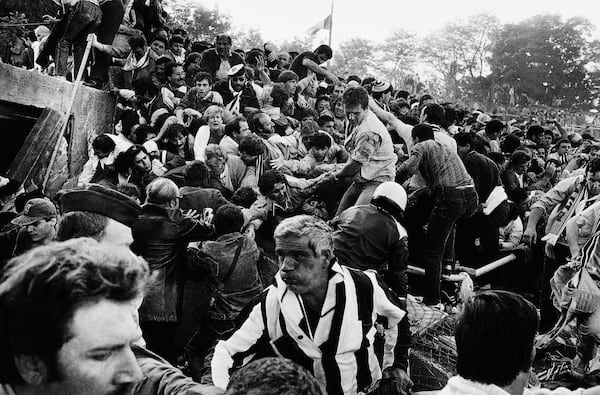 FILE - Soccer fans are crushed against a collapsing wall in the Brussels Heysel stadium just prior to the European Cup final soccer match between Liverpool and Juventus, in Brussels, Belgium, May 29, 1985. (AP Photo/Gianni Foggia, File)