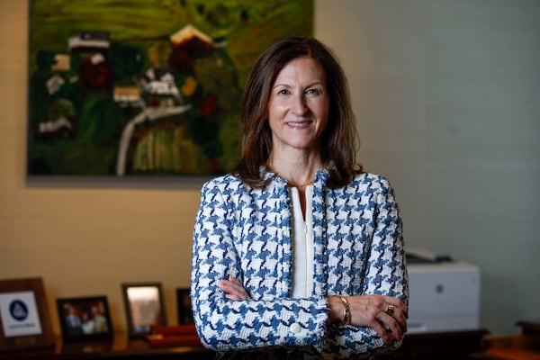 Cheryl Venable, who serves as interim president and chief executive officer at the Federal Reserve Bank of Atlanta, poses for a photograph in her office in the Atlanta Fed building in Midtown Atlanta on Monday, Aug. 17, 2026. Behind her is a painting of her family farm in Oak Ridge, Missouri. She grew up in the white house featured in the painting. (Miguel Martinez/AJC)
