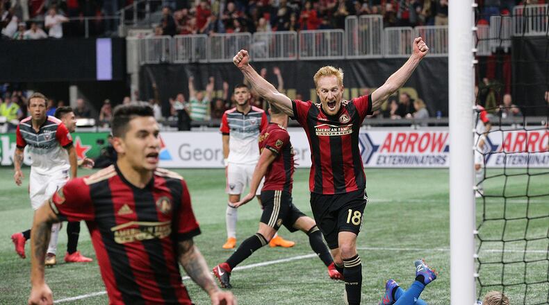 Atlanta United midfielder Jeff Larentowiz (center) and teammates react as a shot by teammate Hector Villalba (far left) gets past D.C. United goalkeeper David Ousted for a 3-0 lead during the second half Sunday, March 11, 2018, in Atlanta. Atlanta United won the game 3-1.