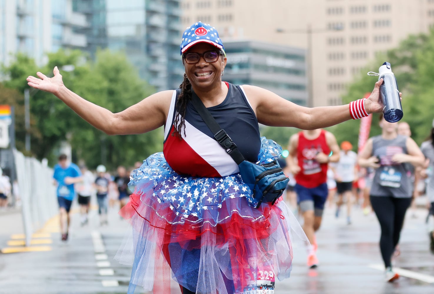 Runners make their way up Peachtree Street during the 54th running of the Atlanta Journal-Constitution Peachtree Road Race in Atlanta on Tuesday, July 4th, 2023.   (Miguel Martinez / Miguel.MartinezJimenez@ajc.com)