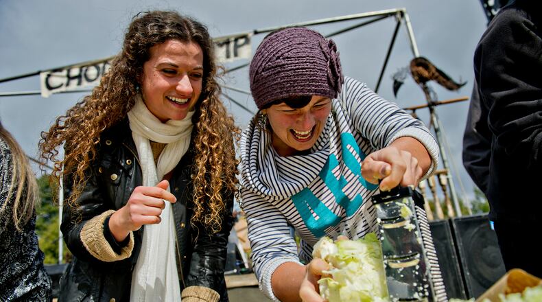 Emma Thibaudeau (left) cheers on Jess Peterick as she shreds cabbage in a competition during the 12th annual Cabbagetown Chomp & Stomp in Atlanta on Saturday, November 1, 2014. The one day festival attracts tens of thousands of people to taste chili, look at art, listen to music and celebrate the historic neighborhood. JONATHAN PHILLIPS / SPECIAL