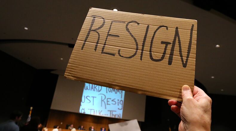 February 28, 2017, Lawrenceville: Rachel Theus holds a resign sign while more protesters demand the resignation of Tommy Hunter, the District 3 leader that recently called U.S. Rep. John Lewis a âracist pigâ on Facebook, during the Gwinnett County Board of Commissioners public hearing session on Tuesday Feb. 28, 2017, in Lawrenceville. Curtis Compton/ccompton@ajc.com