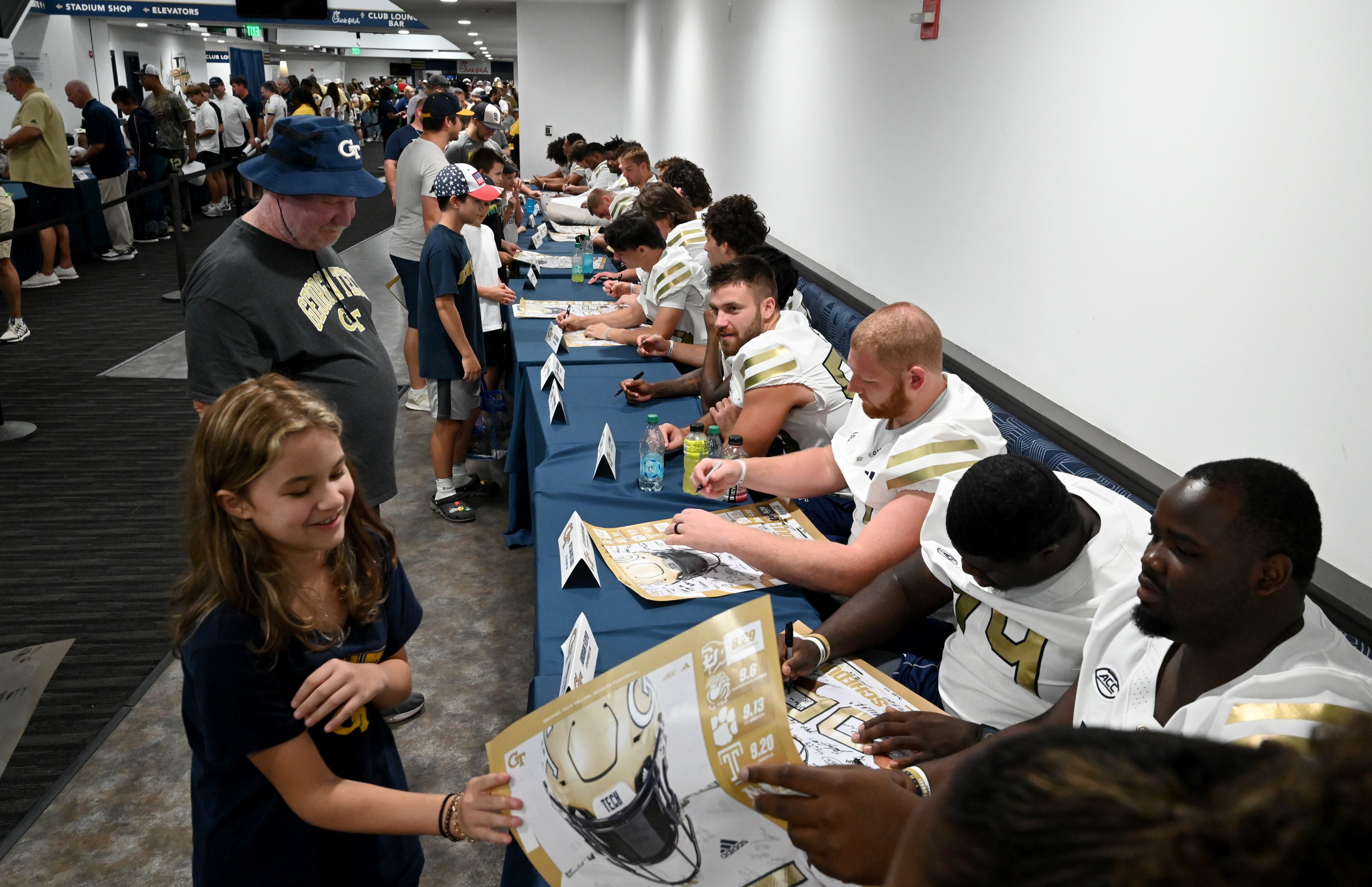 Georgia Tech football players sign autographs for event attendees during the annual “First Saturday on The Flats” at Bobby Dodd Stadium, Saturday, August 2, 2025, in Atlanta. The Flats provides Tech fans with the opportunity to engage with their favorite Yellow Jackets ahead of the upcoming 2025 season. The event offers a variety of entertaining activities for the whole family, including a DJ, autograph opportunities, tailgate games and interactive experiences right on the field at Bobby Dodd Stadium. (Hyosub Shin / AJC)