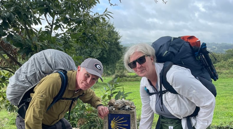Bill Torpy and wife, Julie, pause at the marker saying they have 100 kilometers to go on the El Camino de Santiago.