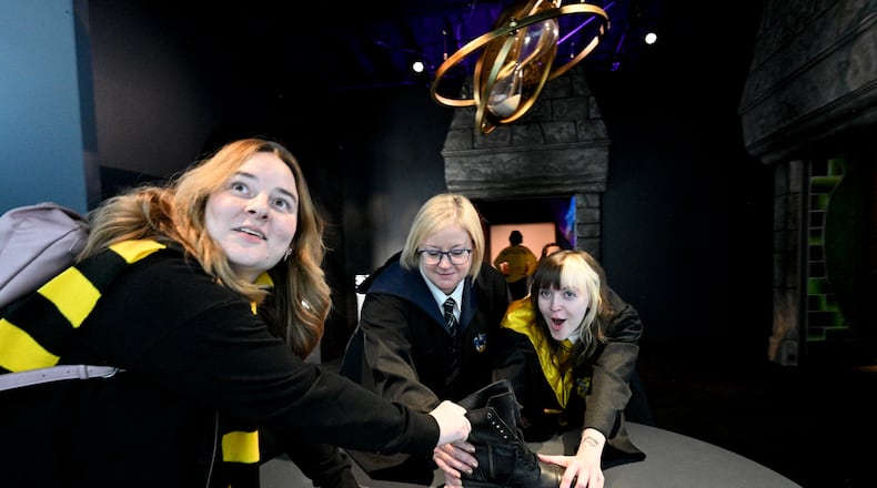 October 21, 2022 Atlanta - Harry Potter fans (from left) Alyssa Burgess, Jessica Simon and her daughter Sunshine Patterson react as they enjoy authentic props, costumes, and interactive technology at 200 Peachtree Street in downtown Atlanta on Friday, October 21, 2022. Created by Atlanta-based Imagine Exhibitions, “Harry Potter: The Exhibition” will take place at 200 Peachtree St. where Macy’s used to be located. (Hyosub Shin / Hyosub.Shin@ajc.com)