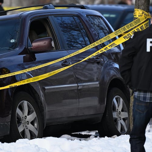 A bullet hole is seen in the windshield as law enforcement officers work the scene of a shooting involving federal law enforcement agents, Wednesday, Jan. 7, 2026, in Minneapolis. (AP Photo/Tom Baker)