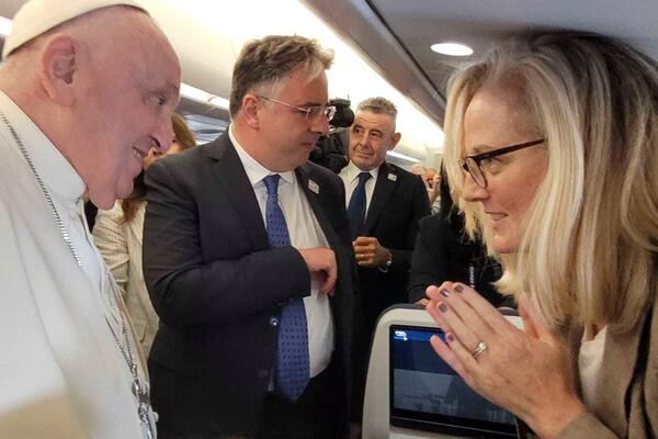 In this photo provided by Jean-Marie Guenois, Associated Press correspondent Nicole Winfield speaks with Pope Francis on his plane en route to Jakarta, Indonesia, on Sept. 2, 2024. (Jean-Marie Guenois via AP)