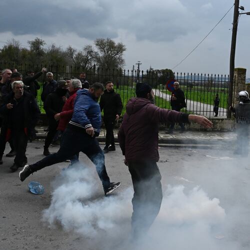 A man kicks a tear gas canister back toward riot police during clashes after farmers tried to block the main access road to Thessaloniki's international airport, northern Greece, on Friday, Dec. 5, 2025, as protests over delays in European Union-backed agricultural subsidy payments escalated. (AP Photo/Giannis Papanikos)
