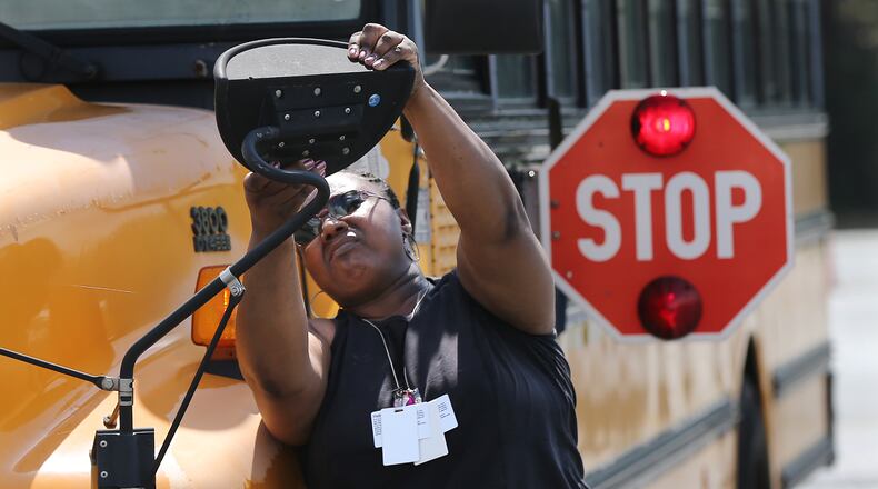 March 28, 2017, Stone Mountain: Bus driver Felicia Evans adjusts a side view mirror while performing a safety check on her bus before leaving the Gregory K. Davis Fleet Service Center at the DeKalb Schools Headquarters to make her afternoon run on Tuesday, March 28, 2017, in Stone Mountain. Curtis Compton/ccompton@ajc.com