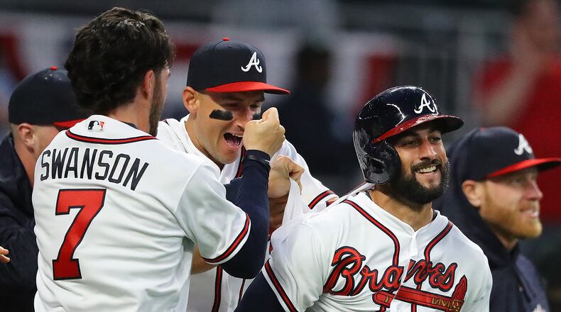 March 29, 2018 Atlanta: Atlanta Braves outfielder Nick Markakis (right) is mobbed by Dansby Swanson and teammates after hitting a walk off 3-RBI home run to beat the Phillies 8 to 5 in a MLB baseball home opening game on Thursday, March 29, 2018, in Atlanta. Curtis Compton/ccompton@ajc.com