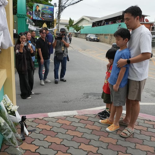People offer prayers at the gate of Debsirin Nonthaburi School, a day after the shooting at the school in Nonthaburi province, Thailand, Saturday, Aug. 8, 2026. (AP Photo/Sakchai Lalit)