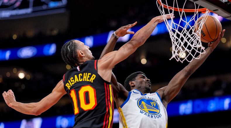 Warriors guard Nate Williams (19) shoots over Hawks forward Zaccharie Risacher during the first half Saturday, March 21, 2026, in Atlanta. Risacher scored 17 points off the bench. (Mike Stewart/AP)