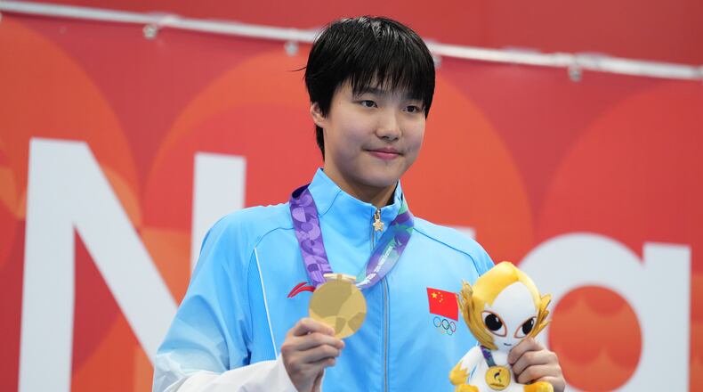 Gold medalist Yu Zidi of China poses on the podium after the women's 200-meter individual medley final in swimming at the Asian Games in Tokyo, Japan, Monday, Sept. 21, 2026. (AP Photo/Hiro Komae)