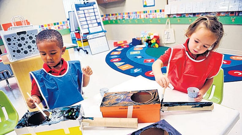 Jason Morton (left) and Layne Sherman, then 4-years-old, make guitars out of shoeboxes and empty paper towel rolls at the Primrose School of Midtown in 2010. The owner opened the center that year after trying unsuccessfully to find intown day care.