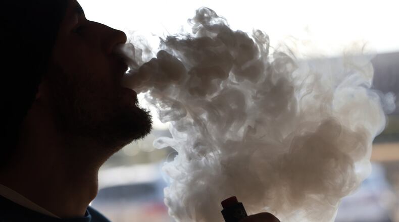 In this Friday, Jan. 18, 2019 file photo, a customer blows a cloud of smoke from a vape pipe at a local shop in Richmond, Va. Although e-cigarettes aren’t considered as risky as regular cigarettes, new research published Monday, May 27, 2019, finds a clue that their flavorings may be bad for the heart. (AP Photo/Steve Helber)