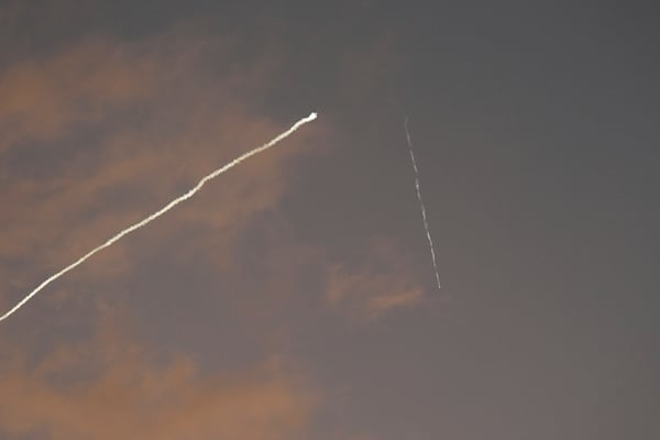 A smoke trail from the Israeli Iron Dome air defense system streaks across the sky as it intercepts missiles launched during an Iranian attack, as seen from Haifa, Israel, early Tuesday, June 24, 2025. (AP Photo/Baz Ratner)
