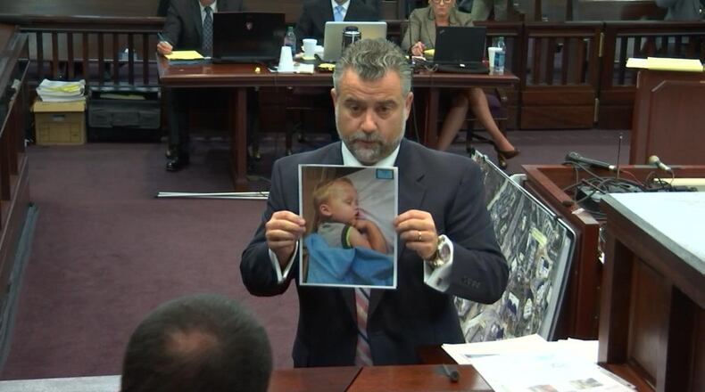 Defense attorney Maddox Kilgore, holding a photo Ross Harris took of his son at his day care, questions lead Detective Phil Stoddard. WSB-TV.