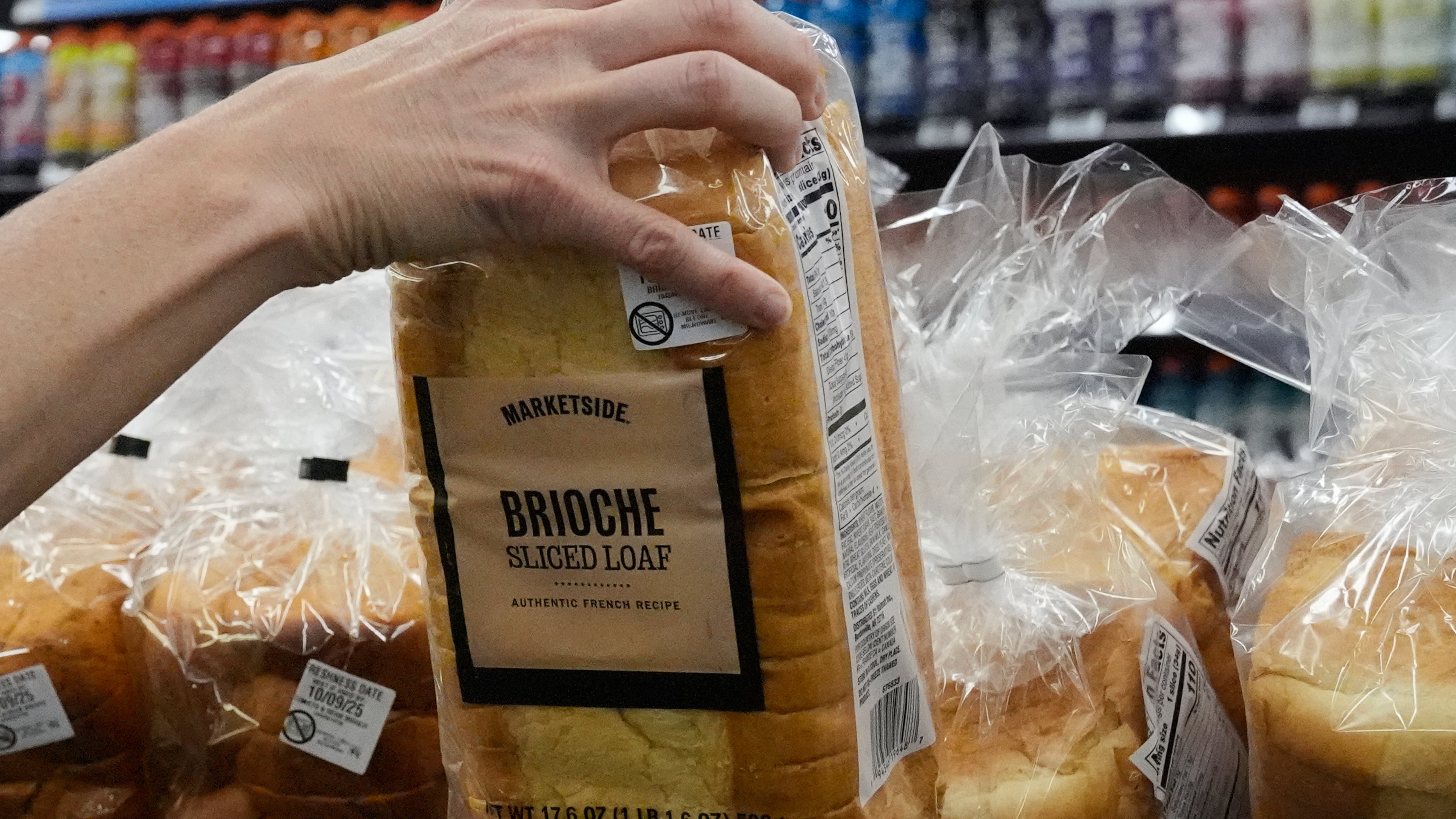 A customer reaches for a loaf of Marketside brand bread at a Walmart Neighborhood Market, Friday, Sept. 26, 2025, in Bentonville, Ark. (AP Photo/Charlie Riedel)