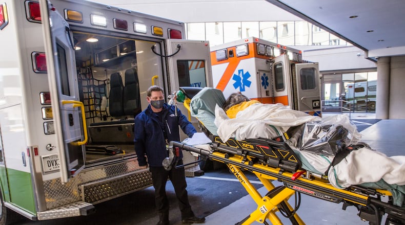 Northeast Georgia Medical Center in Gainesville is dealing with their third surge of Covid cases Thursday, Dec 3, 2020.  A Covid patient is transported by ambulance from the main hospital after tests by Jamerson Kerby back to the Mobile Medical Unit created to keep Covid patients apart from the main facility on campus.  The hospital system has built multiple spaces to keep Covid patients away from the main hospital, however, more than 100 patients are still in standard hospital beds.  The day after Thanksgiving was a record for the hospital in taking Covid patients. (Jenni Girtman for The Atlanta Journal Constitution)