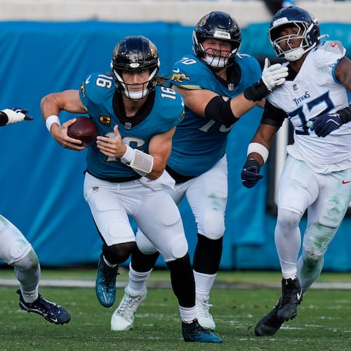 Jacksonville Jaguars quarterback Trevor Lawrence (16) runs the ball past Tennessee Titans outside linebackers Truman Jones (56) and Jaylen Harrell, far right, during the second half of an NFL football game Sunday, Jan. 4, 2026, in Jacksonville, Fla. (AP Photo/John Raoux)