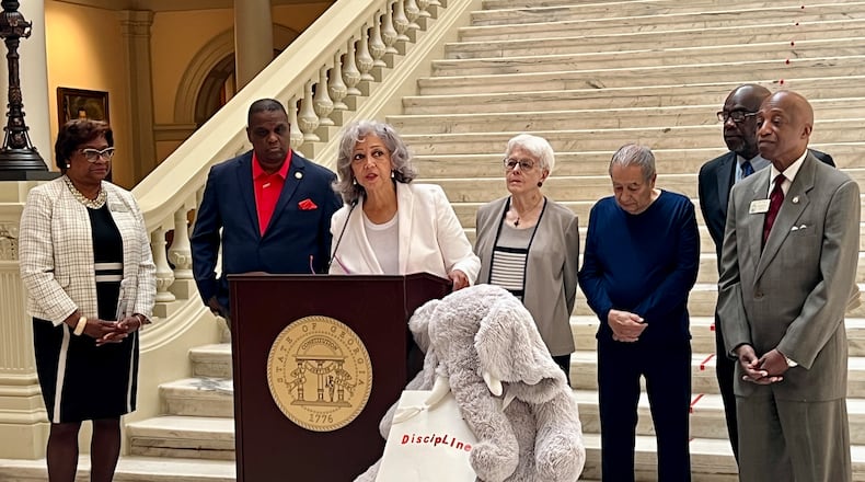 Georgia Federation of Teachers President Verdaillia Turner (center) is joined by past National Parent Teacher Association President and retired Army Lt. Col. Otha Thornton (left, in red shirt), lawmakers and retired educators at the Georgia Capitol on April 28, 2025. They gathered to talk about student discipline, which they called the elephant in the room. The teachers union is proposing addressing acts of violence against teachers by penalizing students' parents. (Cassidy Alexander/AJC)