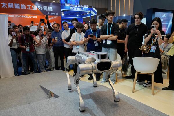 Visitors watch as a four legged robot demonstrates climbing a ramp at the 137th Canton Fair in Guangzhou in southern China's Guangdong province on Wednesday, April 16, 2025. (AP Photo/Ng Han Guan)