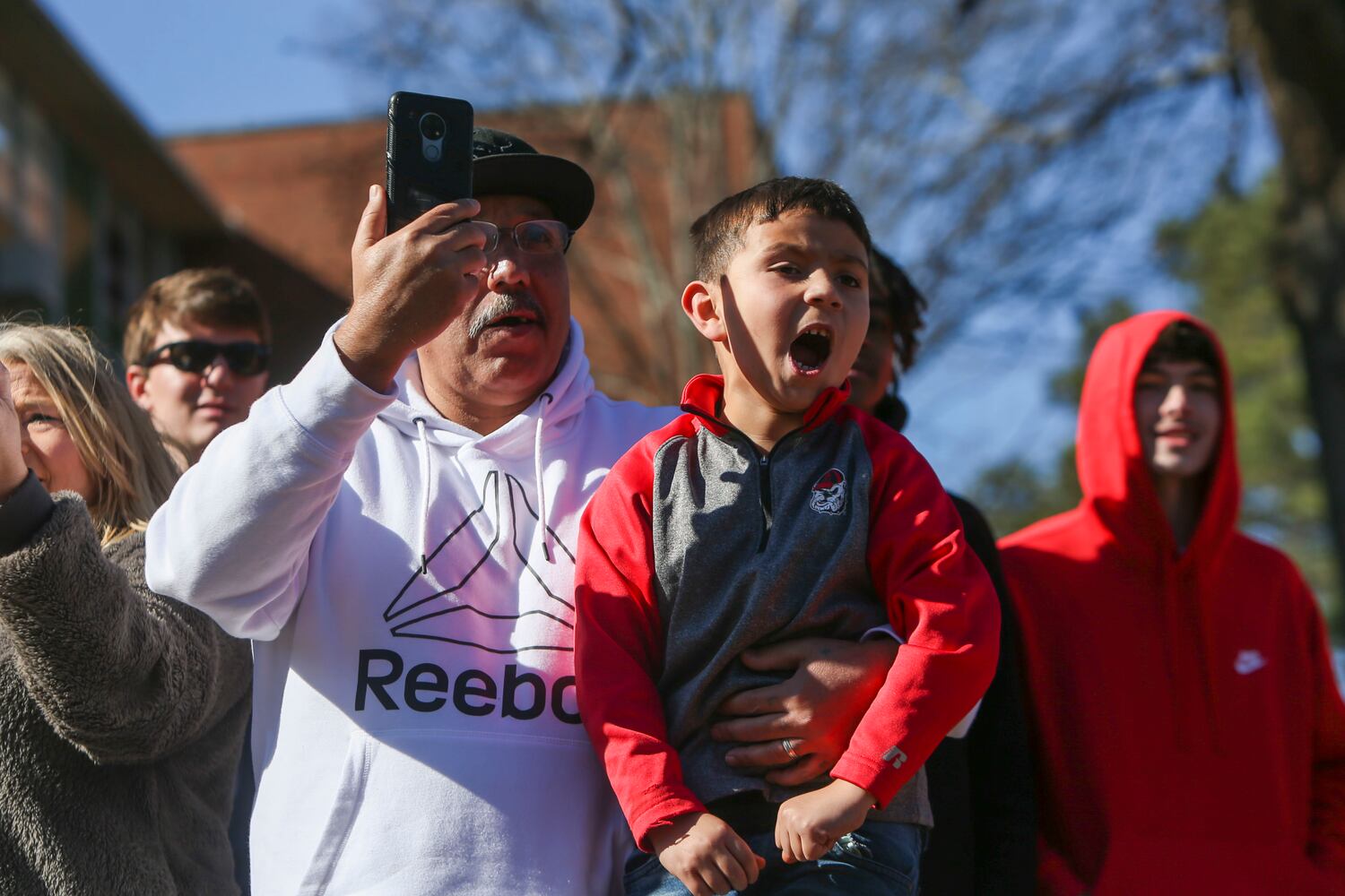 Lupe Lucio (left) and Lucas Aguilar (right) cheer on the football team during the University of Georgia National Championship victory parade on Saturday, January 14, 2023, in Athens, Georgia. The Dawgs waved to fans as they rode down Lumpkin Street. CHRISITNA MATACOTTA FOR THE ATLANTA JOURNAL-CONSTITUTION.