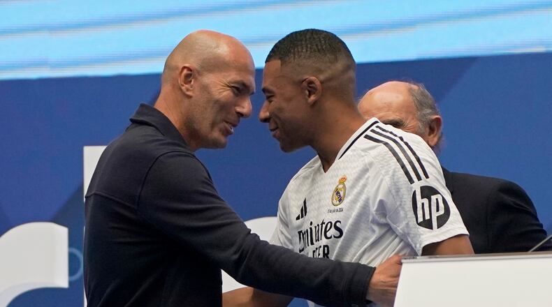 FILE - Former French player Zinedine Zidane, left, embraces Kylian Mbappe of France, as he is being presented to fans as a new Real Madrid player in Madrid, July 16, 2024. (AP Photo/Andrea Comas, File)