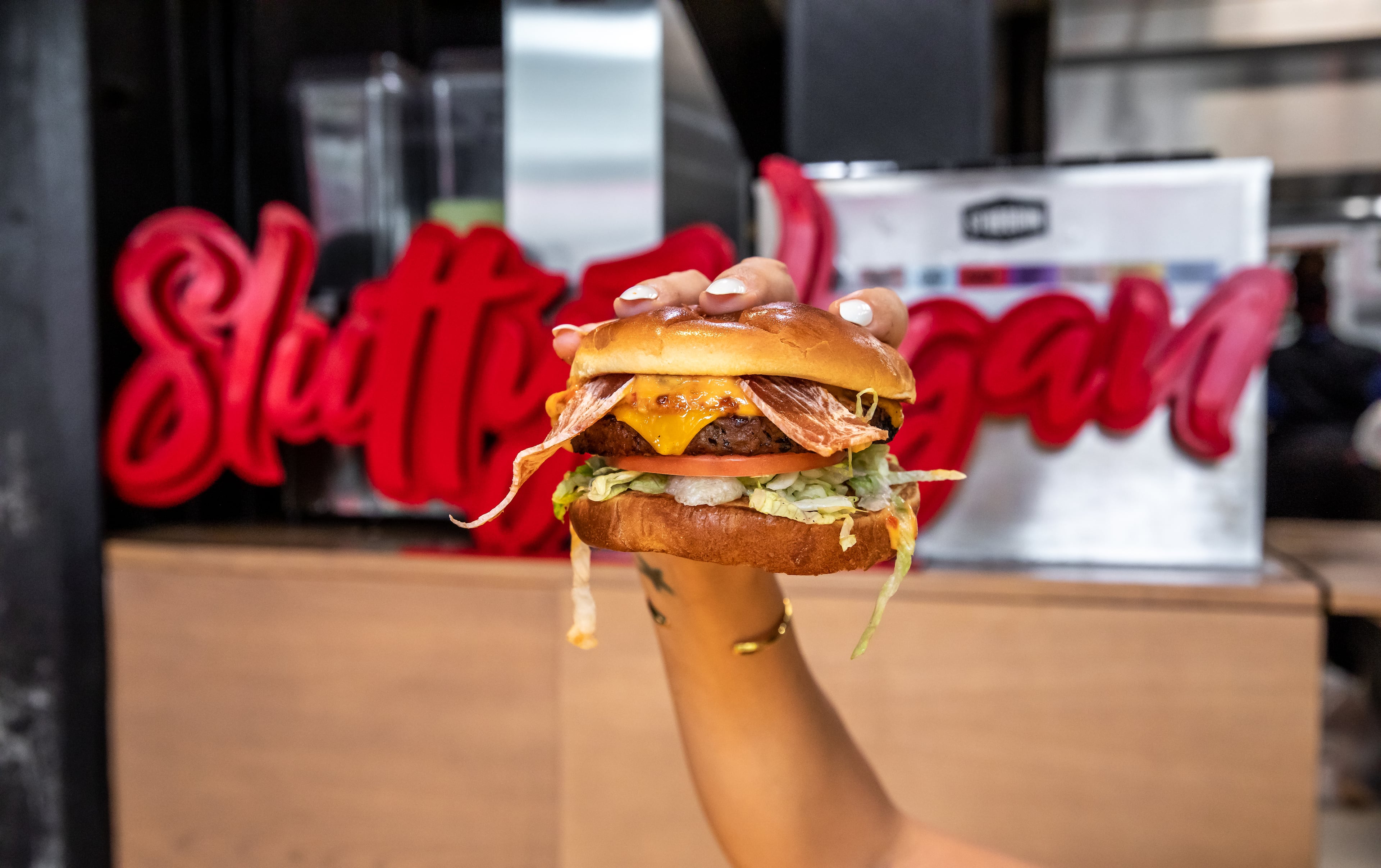 The One Night Stand, a fan-favorite burger from Slutty Vegan, is loaded with vegan bacon, vegan cheese, caramelized onions, lettuce, tomato and "Slut Sauce" on a vegan Hawaiian bun. The popular burger chain has risen to national prominence since its debut as a food truck in 2019. (Courtesy of Madelynne Boykin)