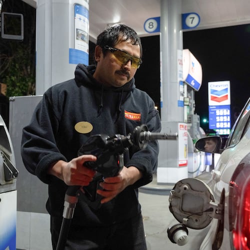 An attendant prepares to fill a customers tank at a gas station on Wednesday, May 6, 2026, in Portland, Ore. (AP Photo/Jenny Kane)