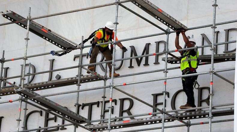 Workers construct scaffolding at the sign for the John F. Kennedy Center for the Performing Arts, Friday, June 12, 2026, in Washington. (AP Photo/Rahmat Gul)